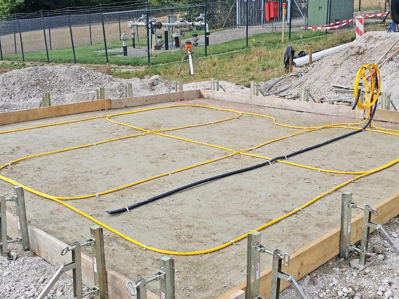 Lhotzky and Partner Monitoring at a gasometric station construction site: Installation of the measuring hose in tight loops to detect a possible tilting or nonuniform settlement of the gasomertic station. Additional: Laying of an empty tube for temperature measurement
